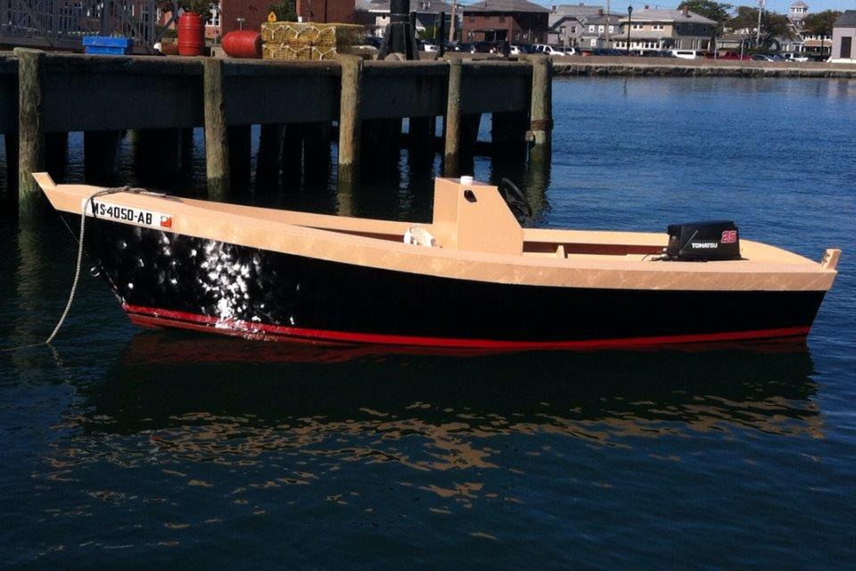 A black and tan customer-built Lady Bug skiff at a mooring